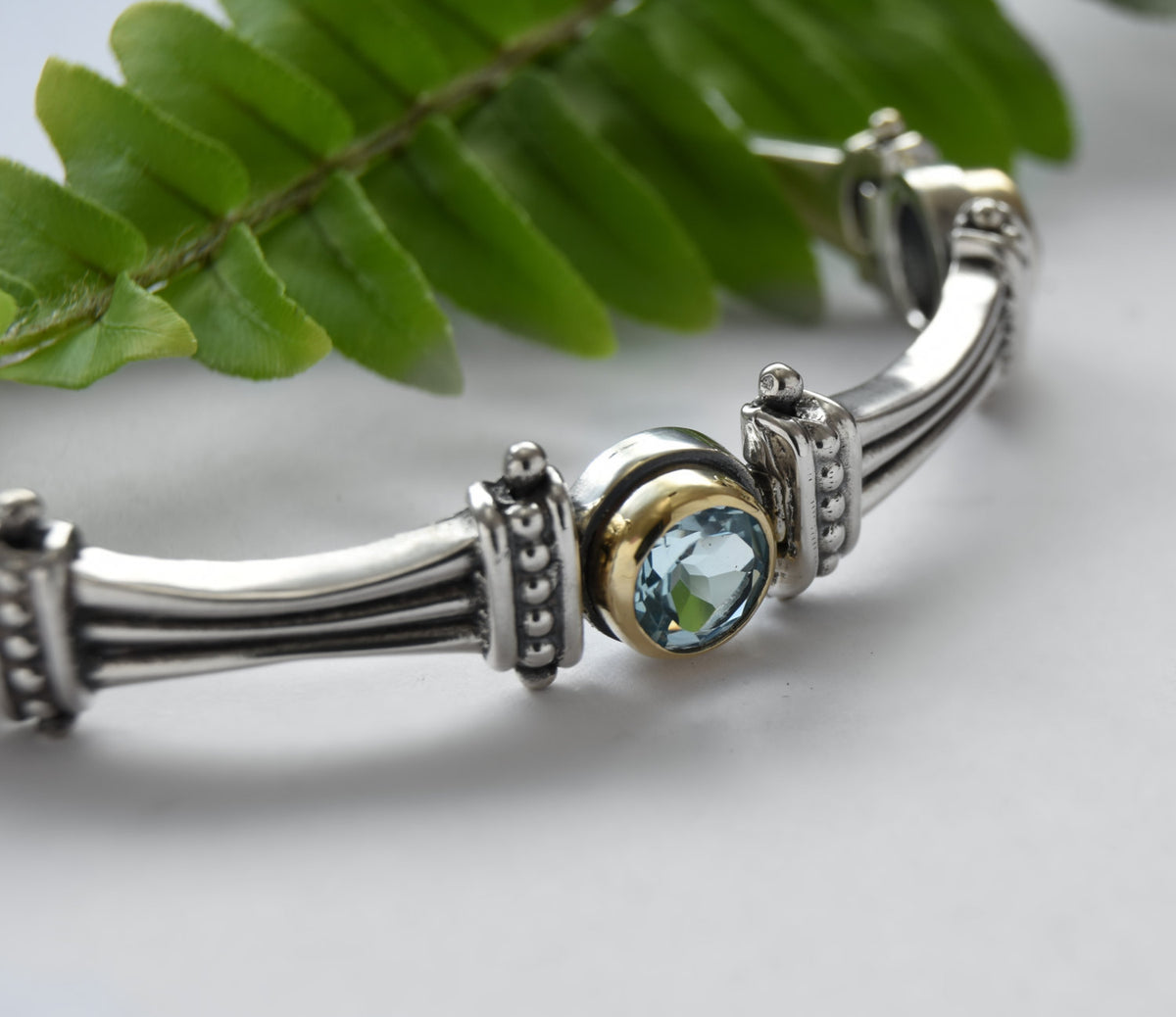 B0647F Silver and Gold Links Bracelet with Blue Topaz