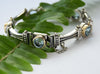 B0647F Silver and Gold Links Bracelet with Blue Topaz